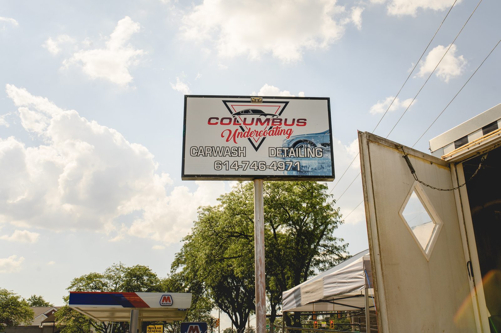 The Columbus Undercoating road sign, showing carwash and detailing and the phone number